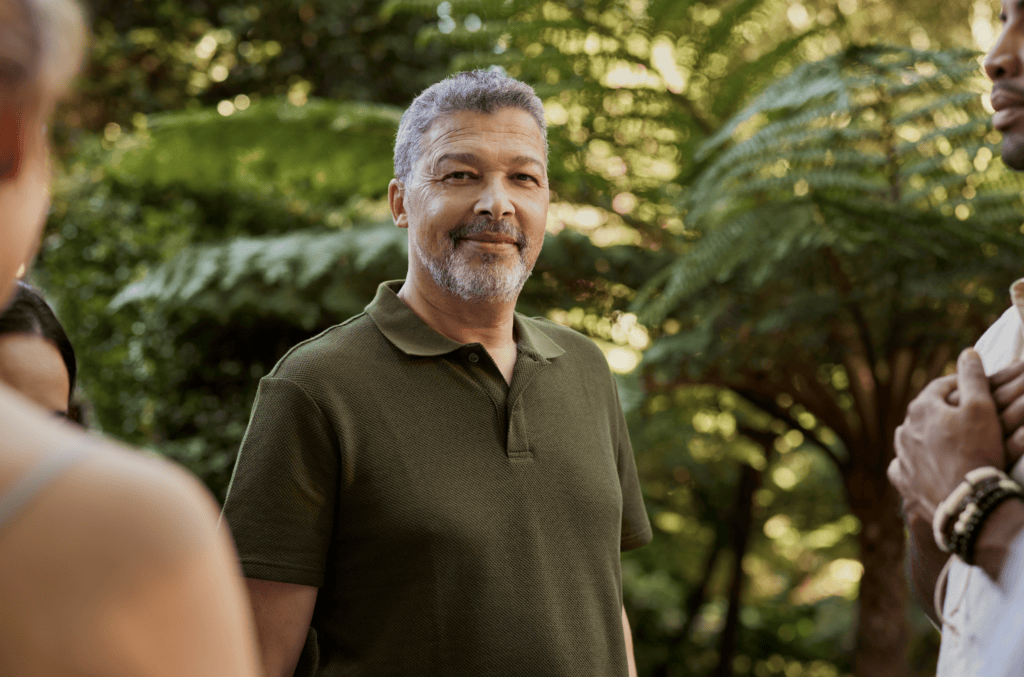 Person speaking with a small group in a wooded outdoor setting